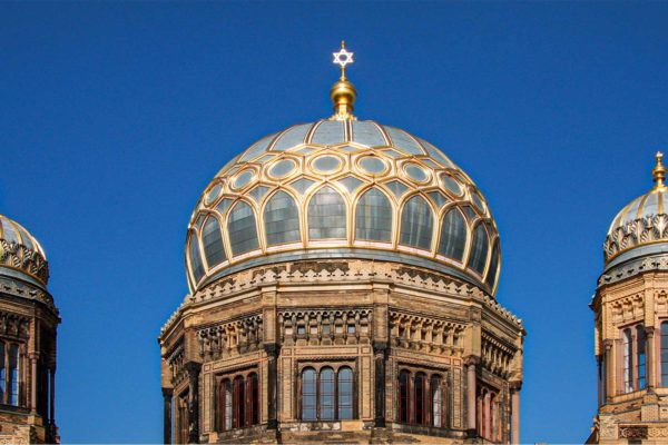 Goldene Kuppel vor strahlend blauem Himmel.